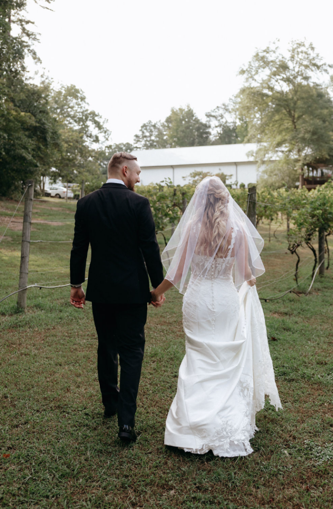 Bride and groom walking amongst the vineyards at Koury Farms